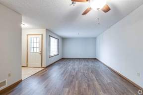 A room with a wooden floor and a ceiling fan.