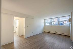 A room with wooden flooring and a large window.