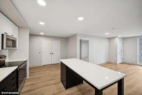 Harbourline Apartments, St Paul an empty living room with a white table and a kitchen