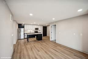 Harbourline Apartments, St Paul an empty living room with a kitchen with a black counter top