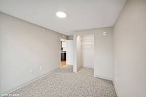Harbourline Apartments, St Paul a renovated living room with white walls and a white closet with a white door
