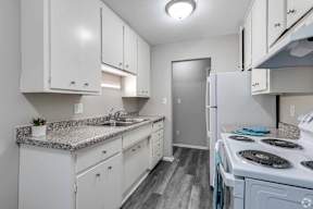 A kitchen with white cabinets and a granite countertop.