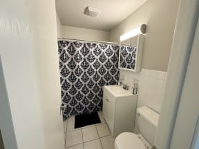 a bathroom with a toilet and a sink and a shower