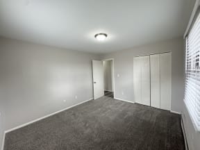 a bedroom with a carpeted floor and a closet