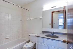 A white bathroom with a toilet, sink, and bathtub.
