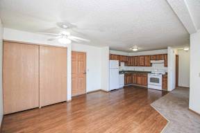 A kitchen with wooden floors and white appliances.
