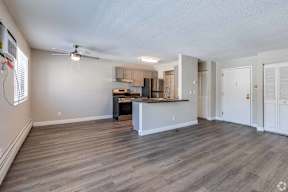 A spacious kitchen with a bar area and a ceiling fan.