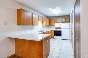 A kitchen with wooden cabinets and a white refrigerator.