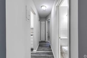 A long white hallway with a door on the right.