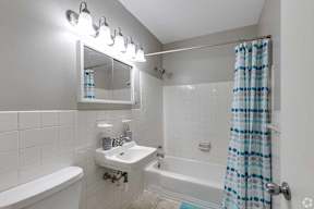A white bathroom with a white tub and sink.