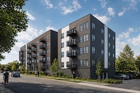 A modern apartment building with balconies on the second floor.