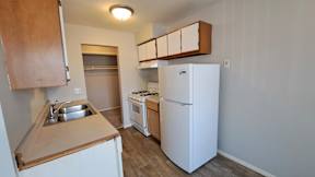 A small kitchen with a sink, stove, and refrigerator.