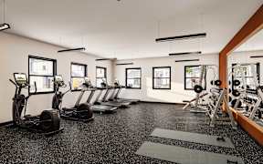 A gym with a row of treadmills and elliptical machines at Sidney Village, Buckeye, AZ