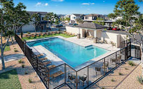 A pool surrounded by a black fence with a small patio area at Sidney Village, Buckeye, AZ 85326