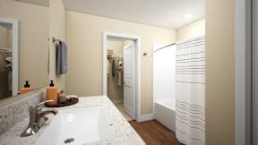 A bathroom with a white sink and a white and beige shower curtain at Sidney Village, Buckeye, AZ