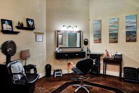 A room with a chair, a mirror, and a television.