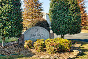A sign that says Home Town in front of some trees.