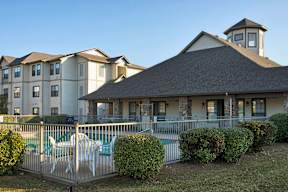A large building with a pool in front of it.