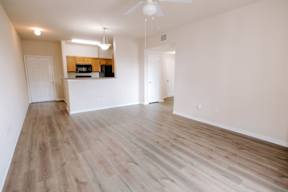 A room with a ceiling fan and wooden flooring.