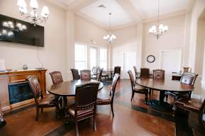 A dining room with a large table and chairs.