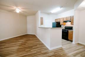 A kitchen area with wooden floors and white walls.