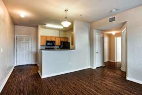 A kitchen area with wooden floors and white walls.