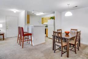 A dining room with a table and chairs.