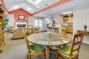 A dining room with a glass table surrounded by chairs.
