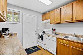 A kitchen with white appliances and wooden cabinets.