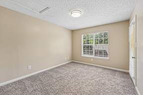 A room with a window and carpeted floor.