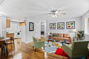 A living room with a brown leather couch and a green chair.
