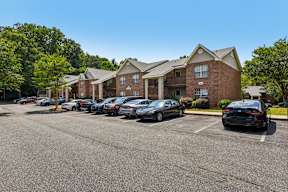 A parking lot with cars and apartment buildings in the background.