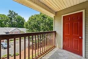 A red door is on the side of a house.