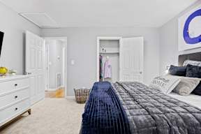 A bedroom with a large bed and a dresser.