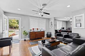 A living room with a ceiling fan and a large couch.