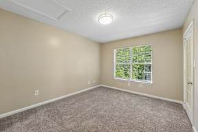 A room with a window and carpeted floor.