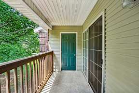A green door is on the left side of a house.