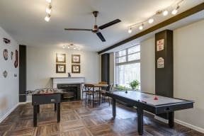 a game room with two pool tables and a ceiling fan