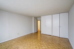 an empty living room with a wood floor and white walls