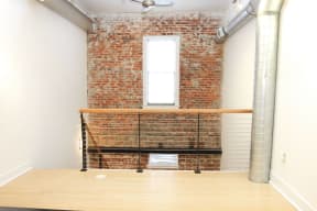 a room with a brick wall and a window