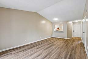 A room with wooden flooring and white walls.