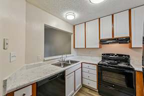 A kitchen with a black stove top oven and a marble counter top.