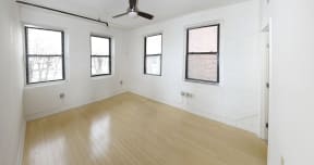 the living room with wood floors and white walls and windows
