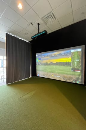 an empty room with a projector screen and a video game on the wallat Metropolis Apartments, Glen Allen