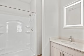 a bathroom with a shower and a sink and a mirrorat Metropolis Apartments, Glen Allen, VA