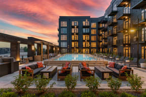 an outdoor pool with lounge chairs and a firepit at dusk at Crossline, Ohio