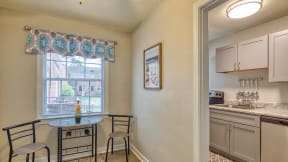 a kitchen with a small table and two chairs next to a window
