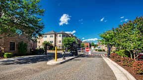 A stop sign is on a gate in front of a building.
