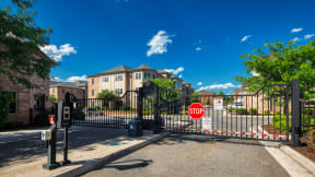 a gate with a stop sign in front of an apartment building