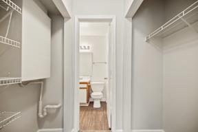 A white bathroom with a toilet and a walk-in closet.